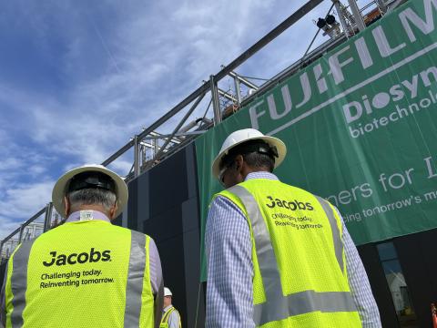 Koti Vadlamudi and Bob Pragada in yellow PPE vest and white hard hats look on to the Fujifilm Diosynth Biotechnologies facility unveiling