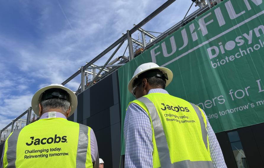 Koti Vadlamudi and Bob Pragada in yellow PPE vest and white hard hats look on to the Fujifilm Diosynth Biotechnologies facility unveiling