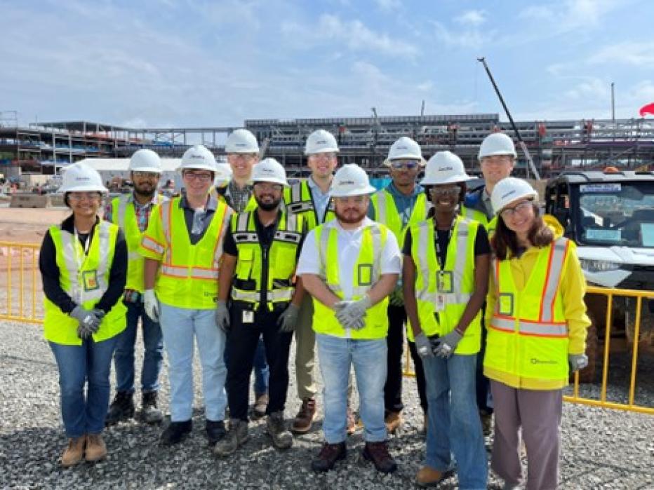 Jacobs interns in yellow PPE vests and white hardhats visit a project site