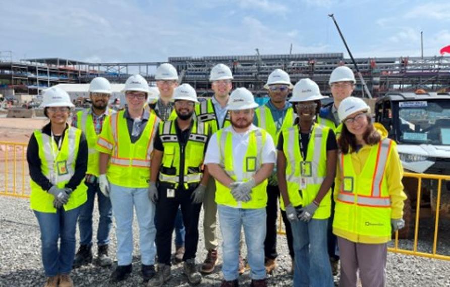 Jacobs interns in yellow PPE vests and white hardhats visit a project site