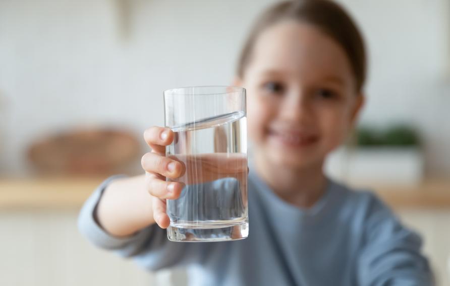 Young boy holding a glass of water