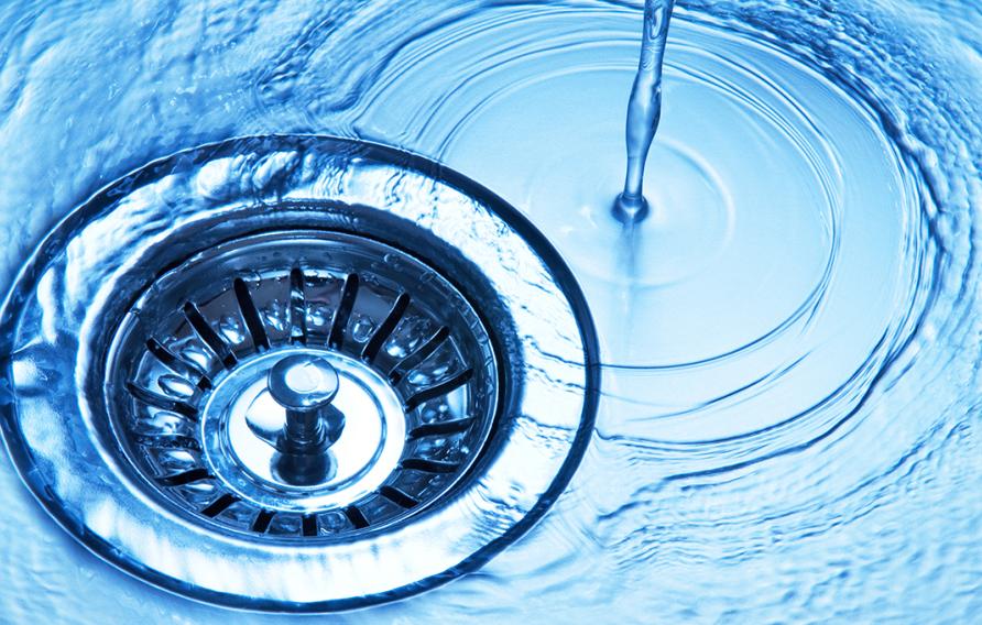 Stock image of water dripping down a drain