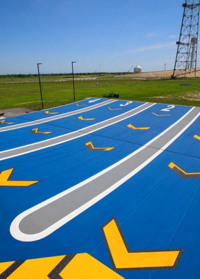 Painted yellow and blue landing strips surrounded by green grass