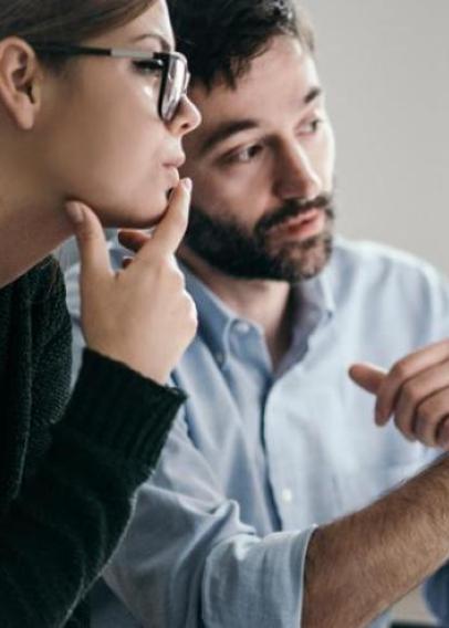 Woman and man looking at a desktop Mac 