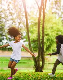 School aged children run in a green park